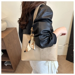 Détail du sac à bandoulière beige en cuir motif serpent avec foulard en soie au manche