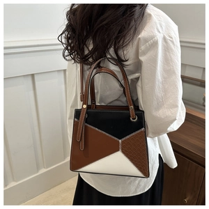 Detail view of contrast stitching and faux crocodile texture on geometric crossbody bag