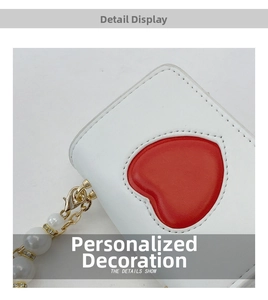 Détail du patch cœur et de la chaîne de perles sur un sac bandoulière en similicuir
