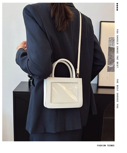Close-up of white mini square handbag featuring a transparent front PVC card slot