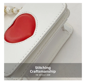Détail d'un mini sac en cuir PU blanc montrant le cœur rouge et les coutures fines