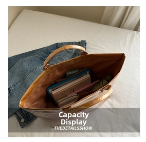 Capacity display of waterproof paper tote bag holding tablet, notebook, and umbrella