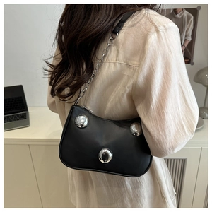 Close-up of black rivet bag with silver metal balls and chain strap detail