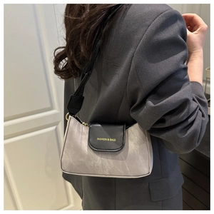 Détail du sac sous l'aisselle bicolore avec lettrage doré et boucle en métal chic