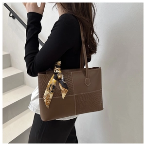 Détail du sac cabas marron avec texture peau de serpent et foulard en soie décoratif