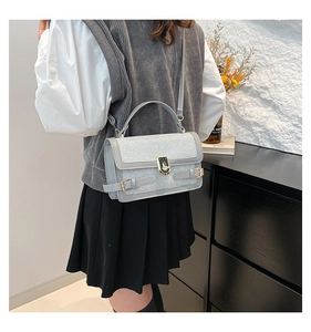 Detail of light blue glitter crossbody bag with metallic clasp and adjustable strap