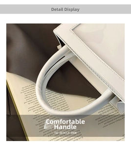 Detail of round handles and stitching on a minimalist white leather cosmetic tote bag
