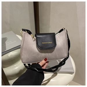 Détail du sac en satin gris avec poignée nouée noire et lettrage doré élégant