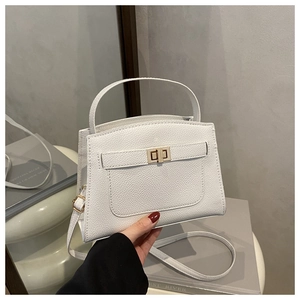 Detail of white lychee grain leather Kelly bag with gold twist lock and handle