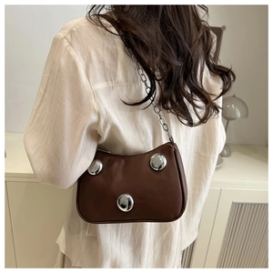 Brown leather shoulder bag featuring silver metal studs and a sleek chain strap