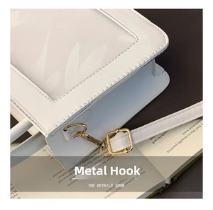 Detailed close-up of light gold metal hooks and white faux leather strap with stitching