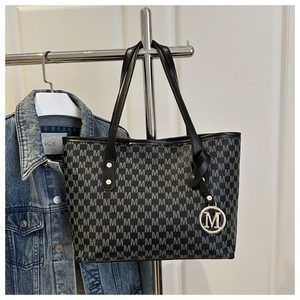 Close-up of retro jacquard tote bag featuring M-pattern and gold metal logo charm