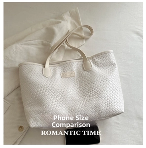 Macro detail of creamy white woven texture leather tote bag with branded square patch