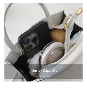 Interior view showing the storage capacity for a phone and makeup in a white handbag