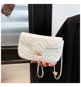 Détail du sac bandoulière blanc matelassé avec fermoir doré et bandoulière chaîne