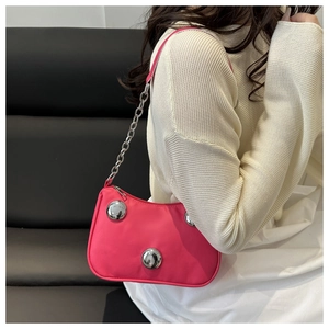 Detail of rose pink crossbody bag featuring distinctive large silver metallic spheres