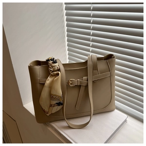 Détail d'un grand sac cabas beige avec foulard en soie et boucle en métal dorée
