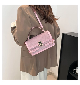 Rear view of a model wearing a pink glitter small square bag with metallic lock detail