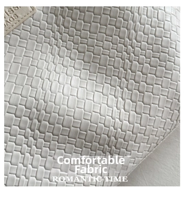 Detail of woven faux leather fabric on the white tote bag with stitched leather tag