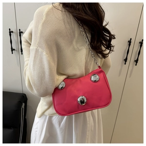 Detail of rose pink crossbody bag featuring three large polished silver metal spheres