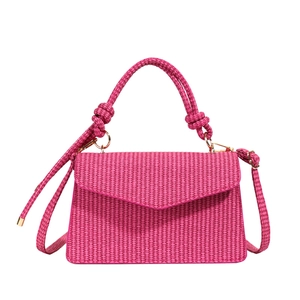 Sac à main carré tissé rose avec poignée élégante et détails dorés sur un fond blanc neutre