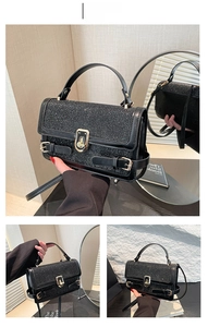 Detail view of black sequin small square bag with golden twist lock and adjustable strap
