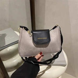 Sac bandoulière minimaliste en tissu gris avec rabat noir et lettrage doré chic