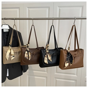 Detailed display of four textured leather tote bags with silk scarves on handles