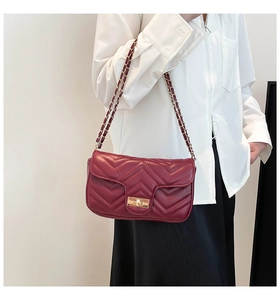 Détail du sac bandoulière en cuir bordeaux avec surpiqûres en V et bandoulière chaîne