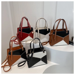 Detail of color-block tote bag with geometric leather patchwork and crocodile embossing