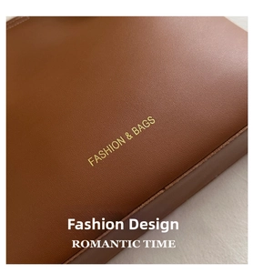Detail of caramel brown lychee grain leather tote with gold embossed fashion lettering