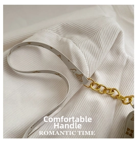 Detail of vintage printed handbag strap with gold chain links and classic floral patterns