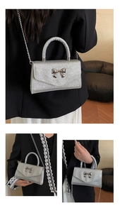 Détail du sac à main à paillettes argentées avec nœud métallique et bandoulière chaîne