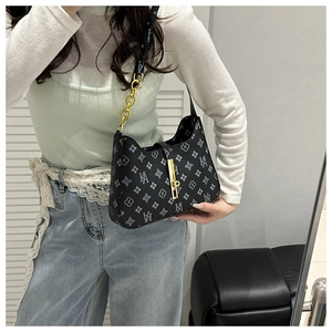 Detail of printed crossbody bag with golden chain strap and metallic lock closure