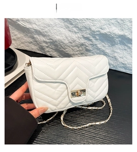 Détail du sac bandoulière matelassé blanc avec fermoir doré et bandoulière chaîne
