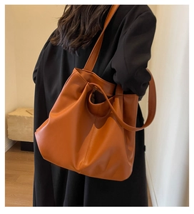 Détail du grand sac cabas orange en similicuir montrant la texture douce et le style ample
