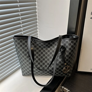 Large capacity tote bag with gray M letter print and gold pendant on a white windowsill