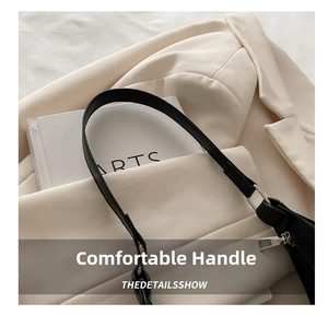 Detail view of smooth black leather handle with fine stitching and silver metal hardware