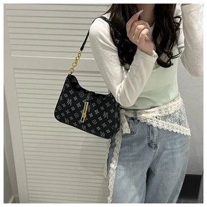 Detail of vintage printed shoulder bag with gold chain strap and metal lock closure