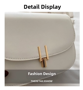 Close-up of white crossbody bag featuring premium gold U-shaped buckle and fine stitching