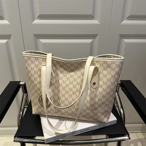 Off-white monogram tote bag with brown letter print and leather straps on a chair