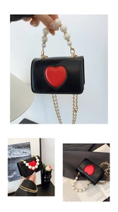 Détail du mini sac bandoulière avec cœur rouge, poignée en perles et chaîne dorée