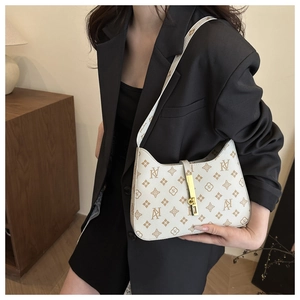Detail of printed vintage shoulder bag showing the gold buckle and monogram pattern