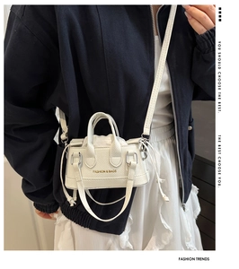 Detail of white lychee grain leather bucket bag with drawstrings and logo print