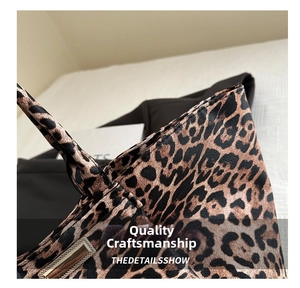 Detailed close-up of leopard print tote bag featuring a polished gold buckle and stitching