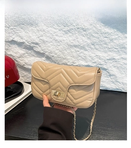 Détail d'un sac bandoulière matelassé kaki avec chaîne dorée et fermoir carré élégant