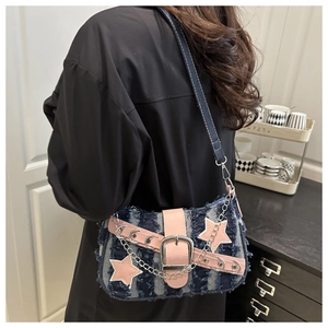 Détail du sac à bandoulière en denim bleu avec sangle rose et boucle étoile argentée
