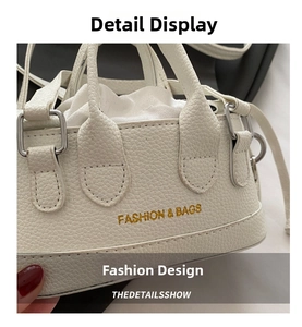 Detail of white lychee leather texture with gold lettering and silver ring buckle
