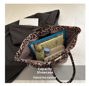 Top view of spacious leopard print tote bag interior holding tablet, umbrella and wallet