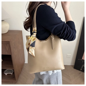 Gros plan d'un grand sac cabas kaki avec lettrage de mode et détail d'un foulard en soie